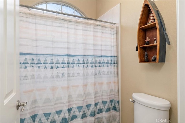 full bath with toilet and a shower with shower curtain