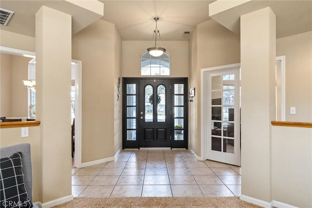 foyer featuring baseboards, visible vents, and light tile patterned flooring