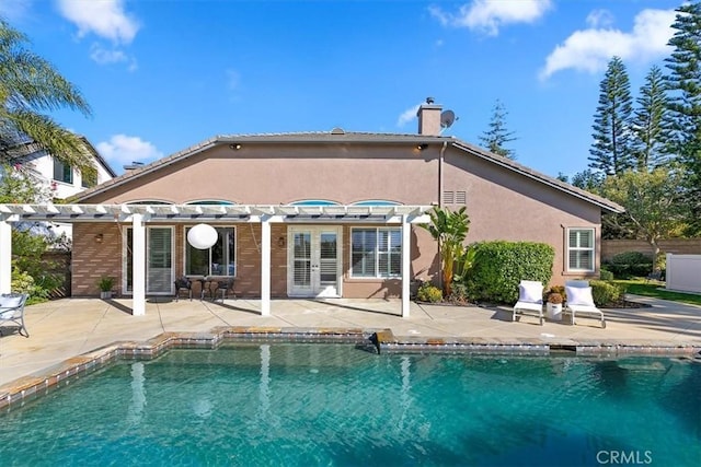 back of house with an outdoor pool, french doors, a patio area, a pergola, and stucco siding