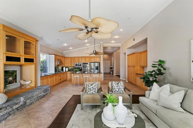 living room with light tile patterned floors, crown molding, vaulted ceiling, and a ceiling fan