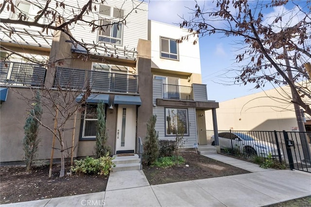 view of property with fence and stucco siding