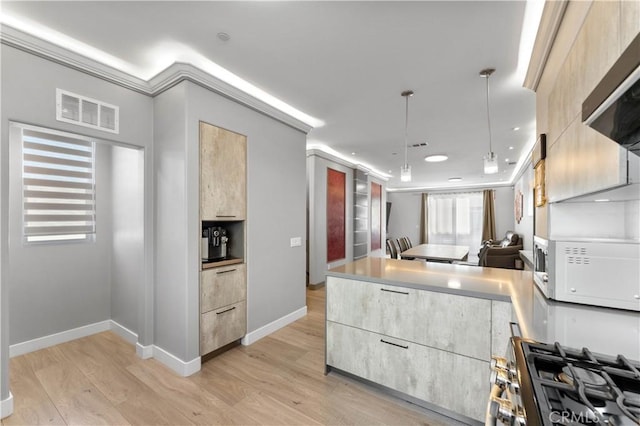 kitchen featuring light countertops, stainless steel gas range oven, modern cabinets, and visible vents