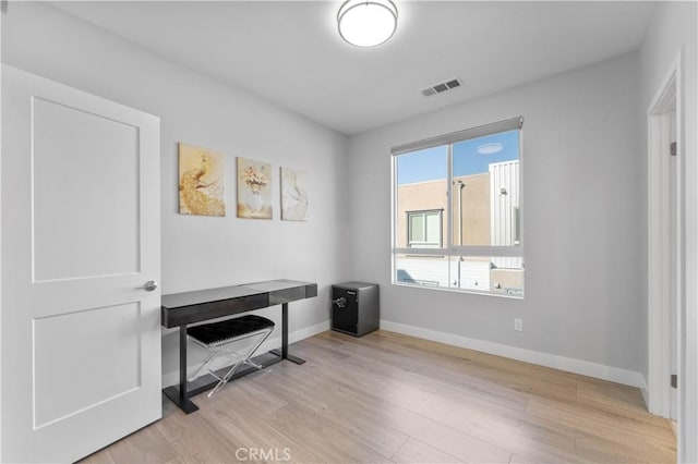 office with light wood finished floors, visible vents, and baseboards