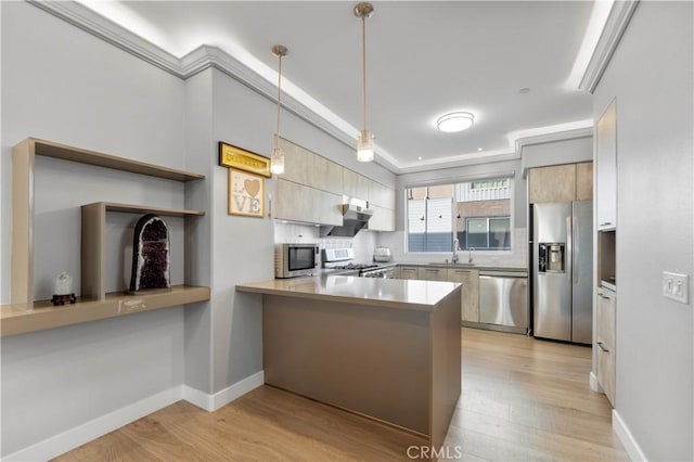 kitchen featuring decorative light fixtures, a peninsula, stainless steel appliances, light countertops, and a sink