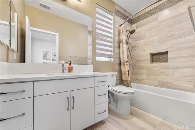 bathroom featuring toilet, visible vents, shower / bath combo with shower curtain, and vanity