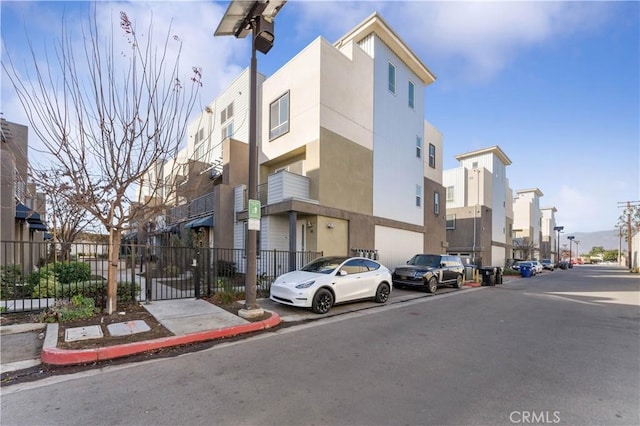 view of building exterior featuring a residential view and fence