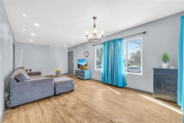 living room with a notable chandelier, wood finished floors, and recessed lighting