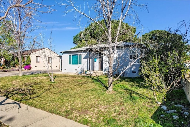 view of front of property with fence, a front lawn, and stucco siding