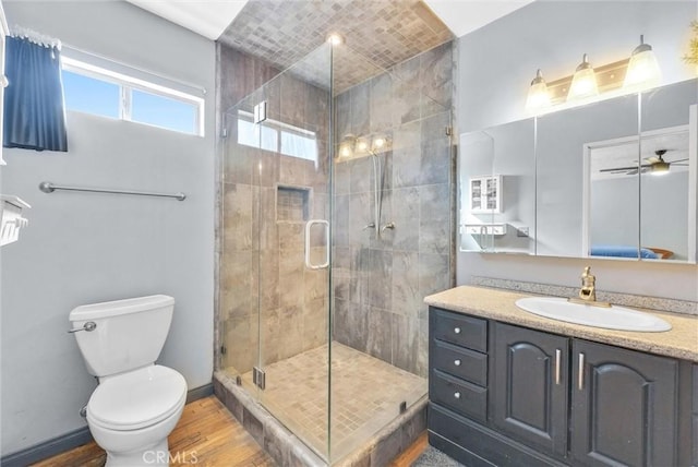 full bathroom with toilet, a ceiling fan, a stall shower, vanity, and wood finished floors