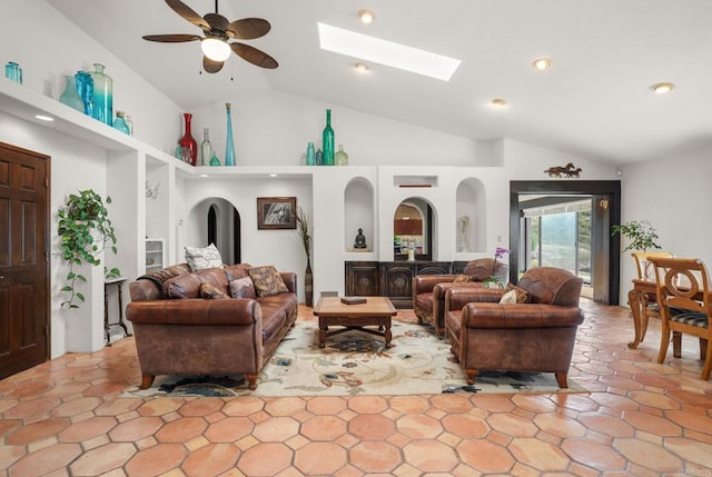 living room with a skylight, arched walkways, a ceiling fan, high vaulted ceiling, and recessed lighting