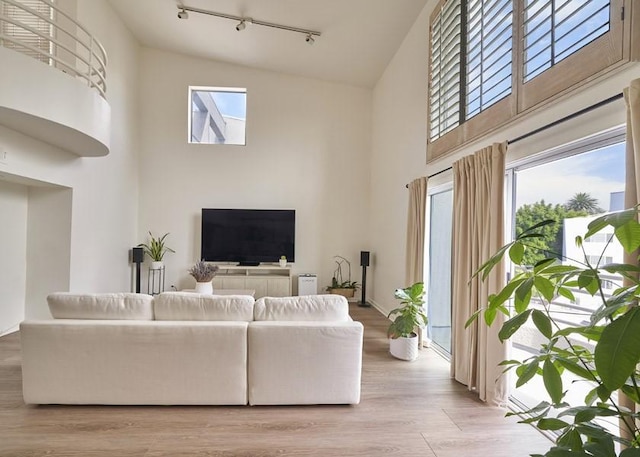 1617 S Beverly Glen Blvd Unit 303, Los Angeles, CA 90024 - living room featuring a high ceiling, rail lighting, plenty of natural light, and light wood-type flooring