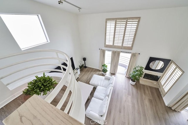 1617 S Beverly Glen Blvd Unit 303, Los Angeles, CA 90024 - living area with healthy amount of natural light, wood finished floors, a fireplace, rail lighting, and a towering ceiling