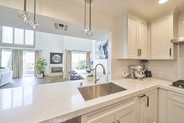 1617 S Beverly Glen Blvd Unit 303, Los Angeles, CA 90024 - kitchen featuring a sink, open floor plan, light countertops, white cabinets, and a high ceiling