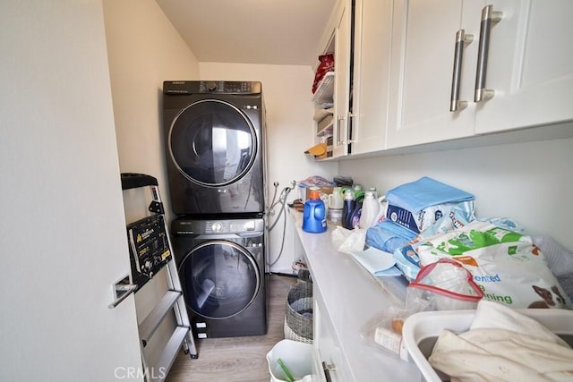 1617 S Beverly Glen Blvd Unit 303, Los Angeles, CA 90024 - washroom featuring stacked washer and clothes dryer, wood finished floors, and cabinet space