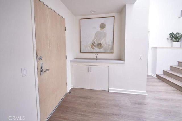 1617 S Beverly Glen Blvd Unit 303, Los Angeles, CA 90024 - corridor featuring light wood-type flooring, stairway, and baseboards