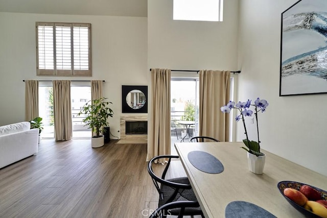 1617 S Beverly Glen Blvd Unit 303, Los Angeles, CA 90024 - dining area with a towering ceiling, a high end fireplace, and wood finished floors