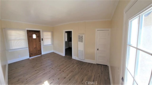 foyer entrance featuring dark wood-type flooring, crown molding, and baseboards