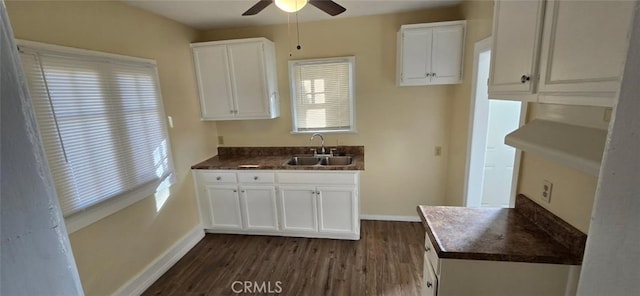 kitchen featuring dark countertops, a sink, and white cabinets