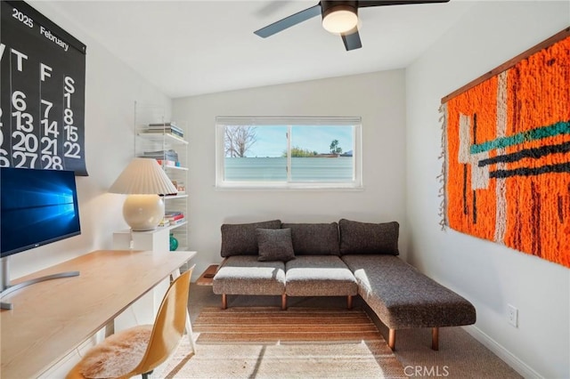 living area featuring lofted ceiling and a ceiling fan