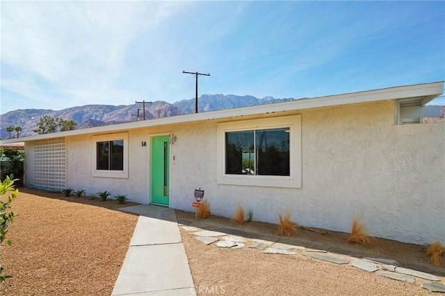 single story home featuring a mountain view and stucco siding