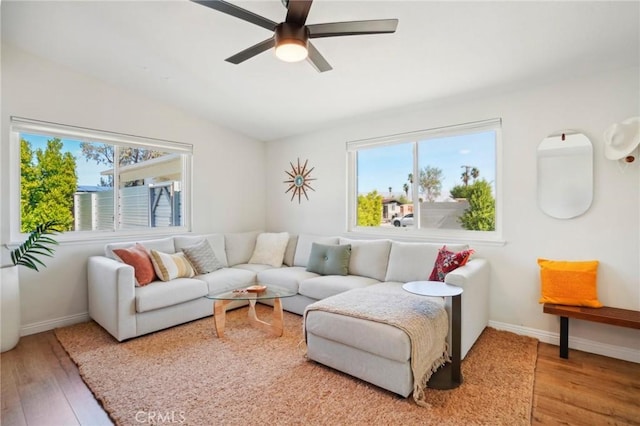 living room featuring vaulted ceiling, a wealth of natural light, and wood finished floors