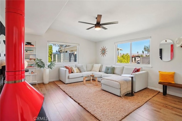 living area with light wood finished floors, baseboards, and a ceiling fan