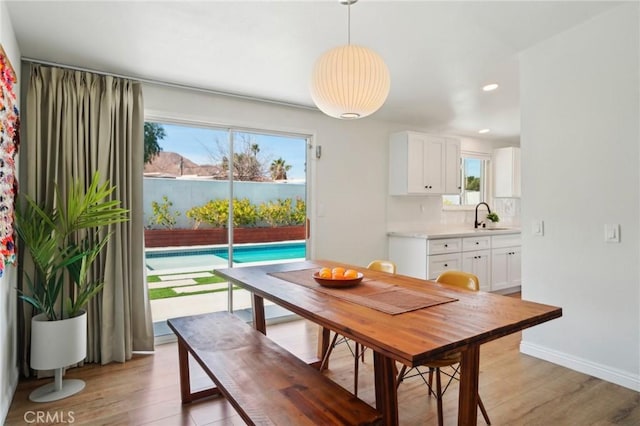 dining area with recessed lighting, light wood-style flooring, and baseboards