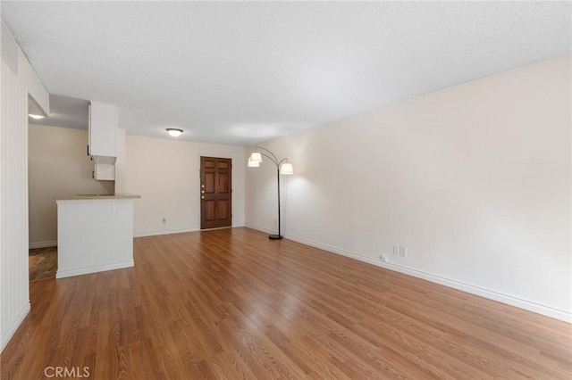 unfurnished living room featuring baseboards and light wood-style floors