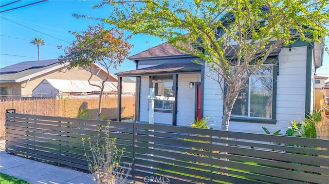 view of front of house featuring roof with shingles and a fenced front yard