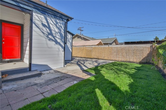 view of yard with entry steps, a fenced backyard, and a patio