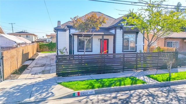 view of front of house featuring a fenced front yard and a chimney