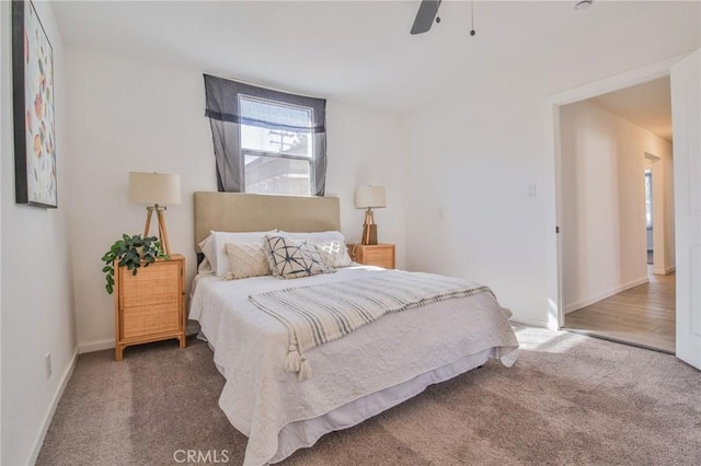 bedroom featuring baseboards, dark carpet, and a ceiling fan