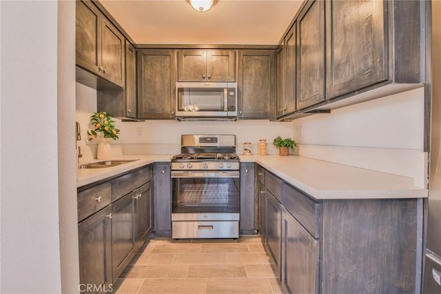 kitchen with a sink, dark brown cabinetry, stainless steel appliances, and light countertops