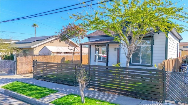 view of front of property with a fenced front yard and a gate