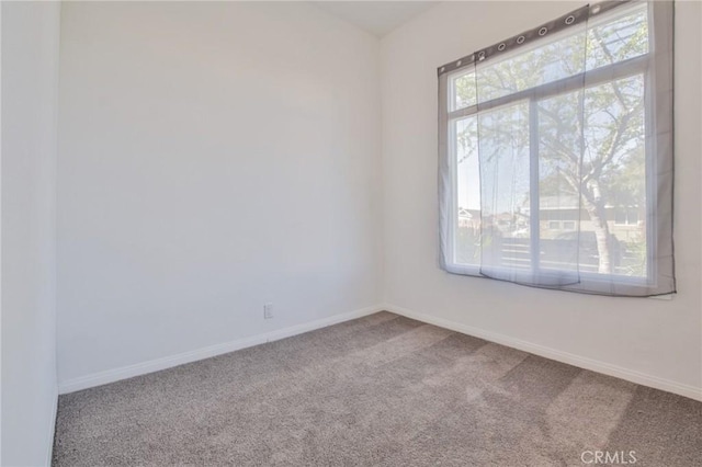 carpeted spare room with baseboards