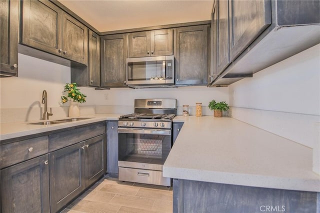 kitchen with stainless steel appliances, light countertops, a sink, and dark brown cabinetry