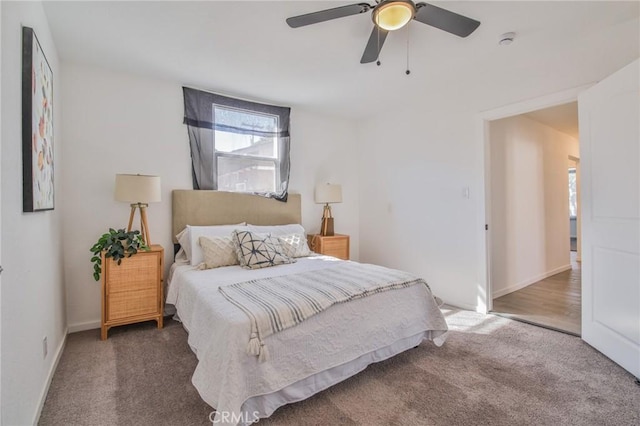 bedroom featuring dark colored carpet, a ceiling fan, and baseboards