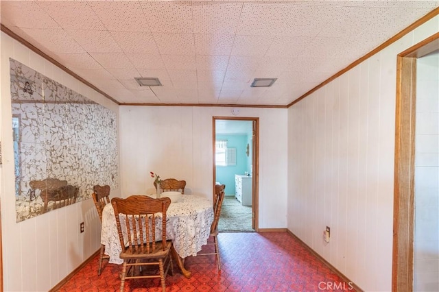 interior space featuring wood walls and ornamental molding