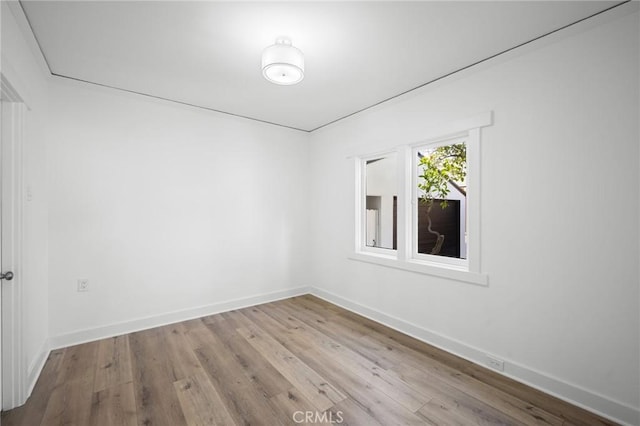 empty room featuring light wood-style floors and baseboards