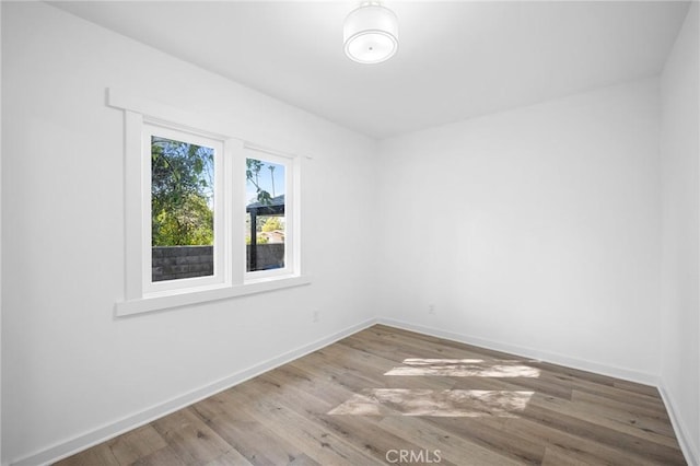 empty room with baseboards and wood finished floors