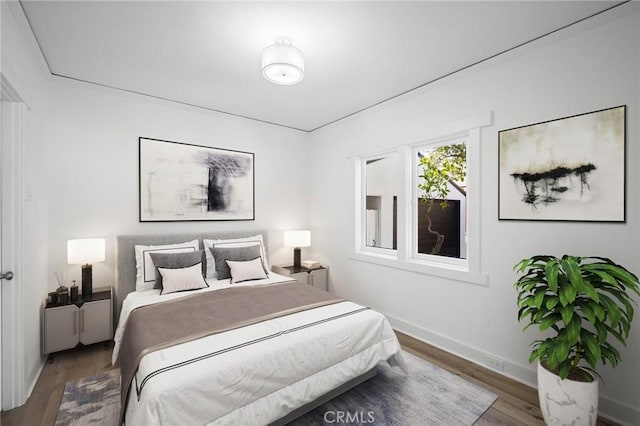 bedroom with dark wood finished floors and baseboards