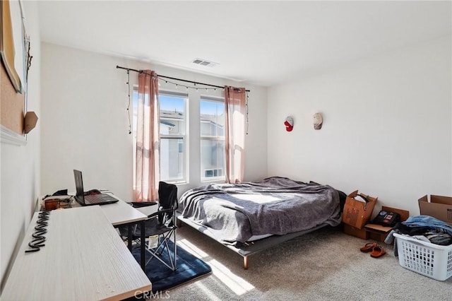 carpeted bedroom featuring visible vents