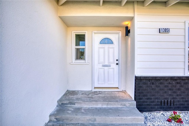 entrance to property featuring stucco siding