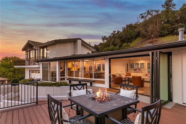 exterior space with a balcony, stucco siding, and an outdoor living space with a fire pit