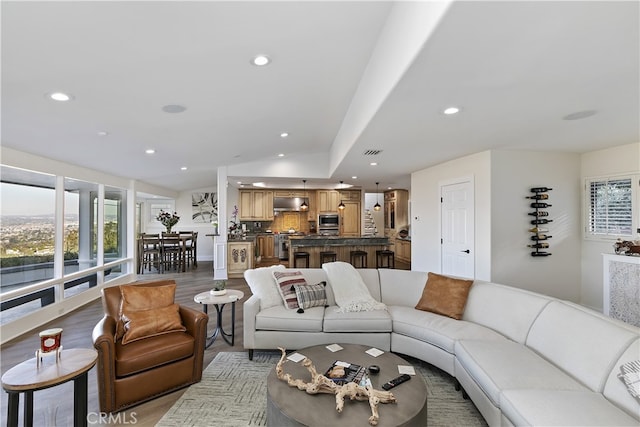 living area featuring light wood-type flooring, visible vents, lofted ceiling, and recessed lighting