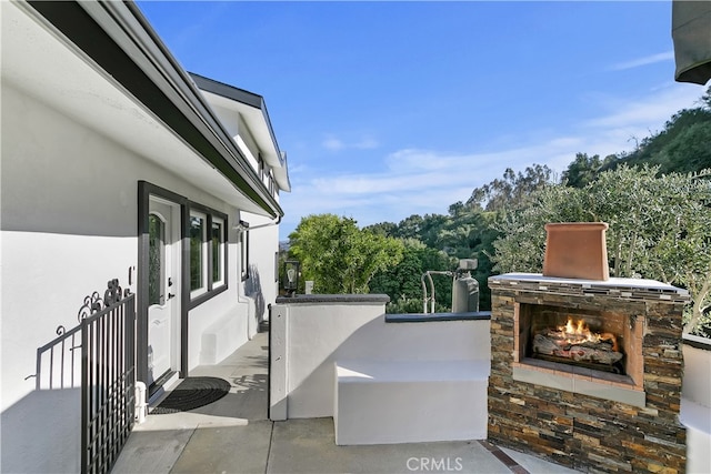 view of patio / terrace with an outdoor stone fireplace