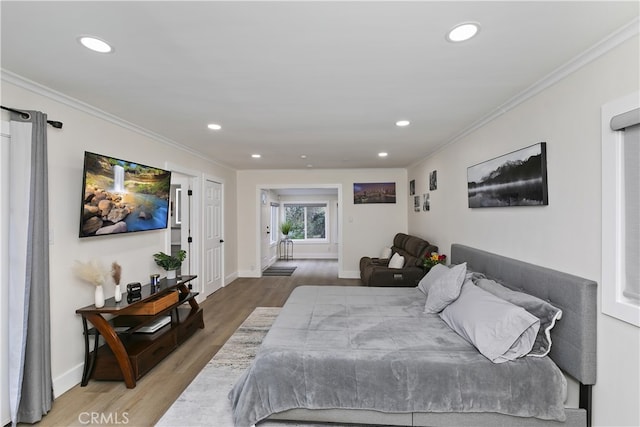 bedroom with baseboards, ornamental molding, wood finished floors, and recessed lighting