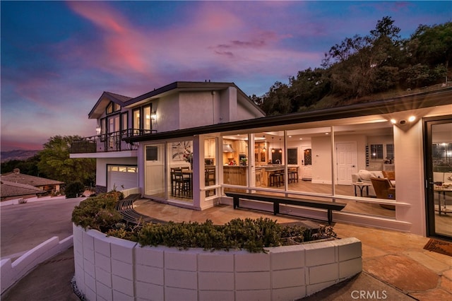 exterior space with a balcony and stucco siding