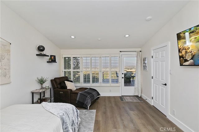 bedroom with recessed lighting, wood finished floors, baseboards, vaulted ceiling, and access to outside