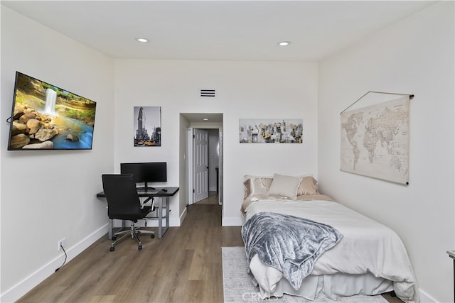 bedroom with baseboards, visible vents, wood finished floors, and recessed lighting